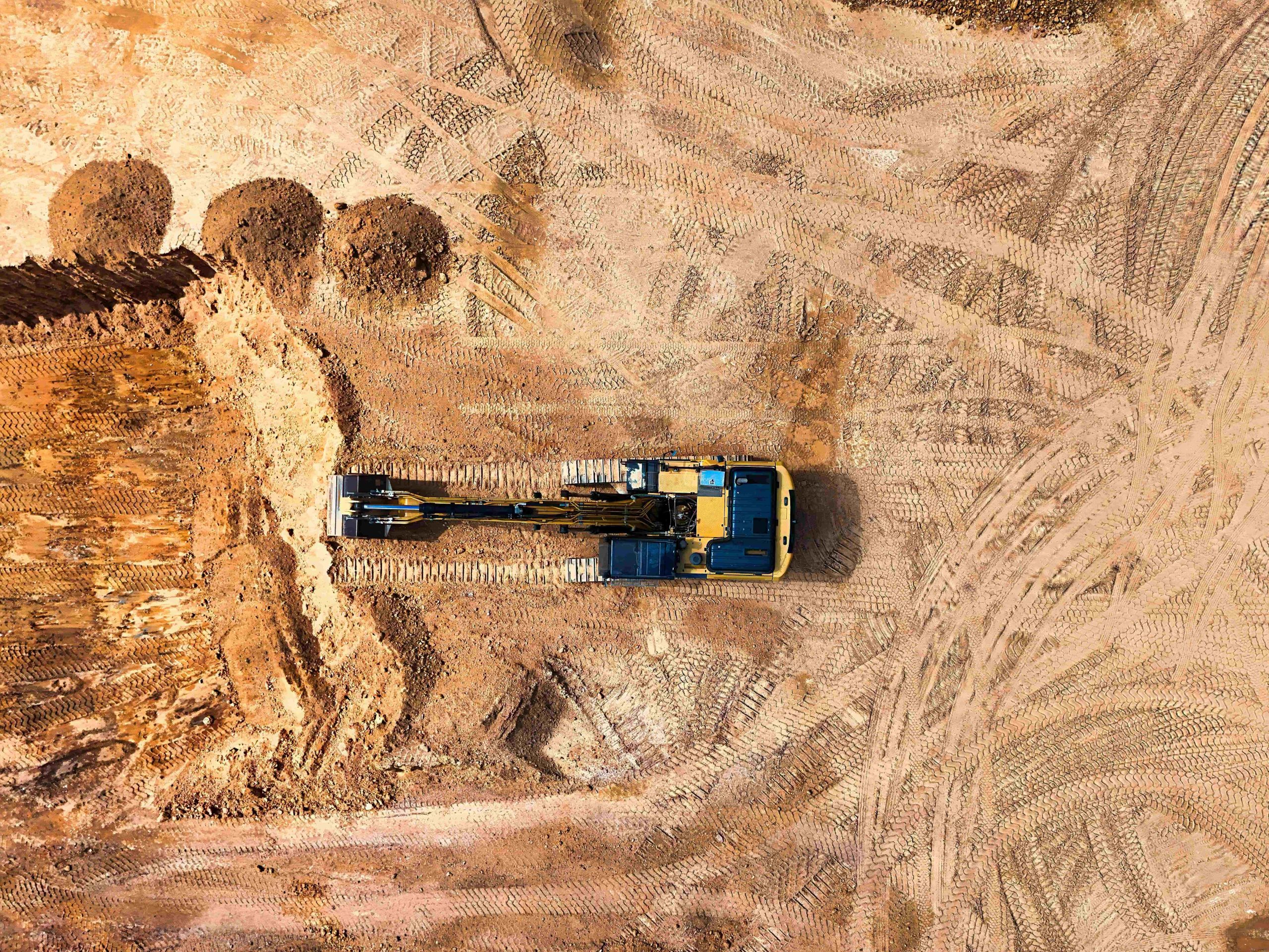 Aerial view of an excavator clearing earth on a construction site